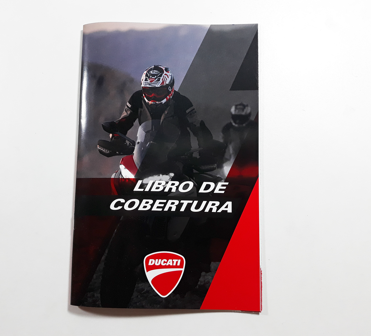 books for ducatti Cover of a 'Libro de Cobertura' featuring a motorcycle rider on a Ducati bike, with a focus on the Ducati logo and the red and black color scheme